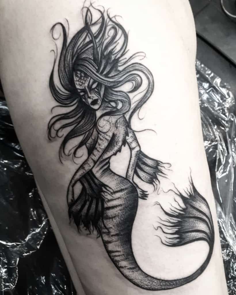 Blackwork tattoo of a mystical siren with flowing hair, detailed scales, and a fiery, ethereal tail design