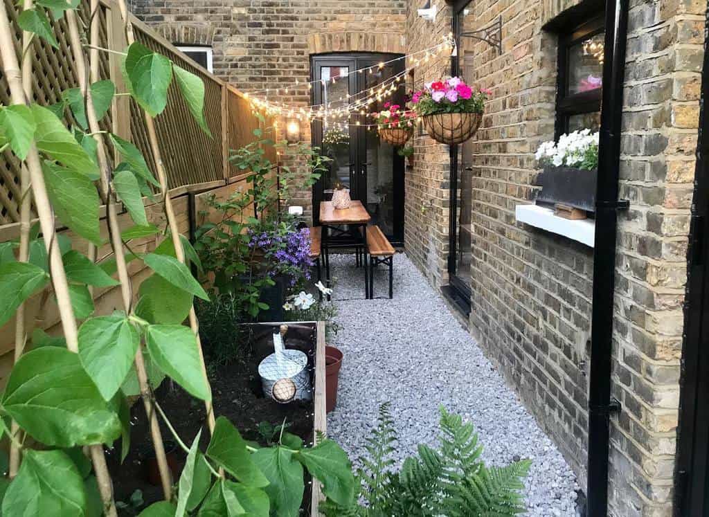 narrow backyard with gravel surface and bench with table