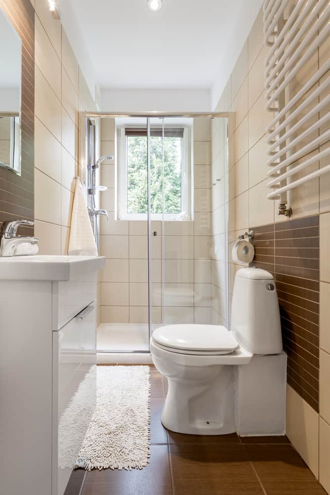 small narrow bathroom with brown and white tiles