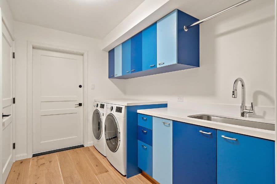 blue cabinet laundry with large sink washer and dryer