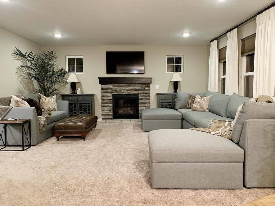 large living room with stone fireplace and gray sofa 