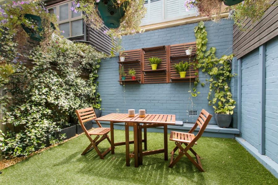 small patio with astro turf wood table and chairs