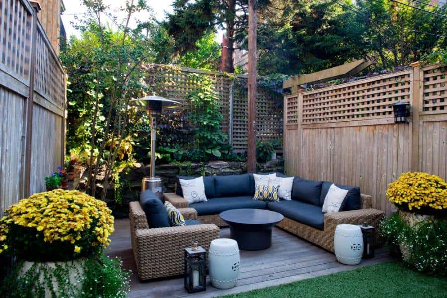 small wood deck patio with wicker sofa and armchair