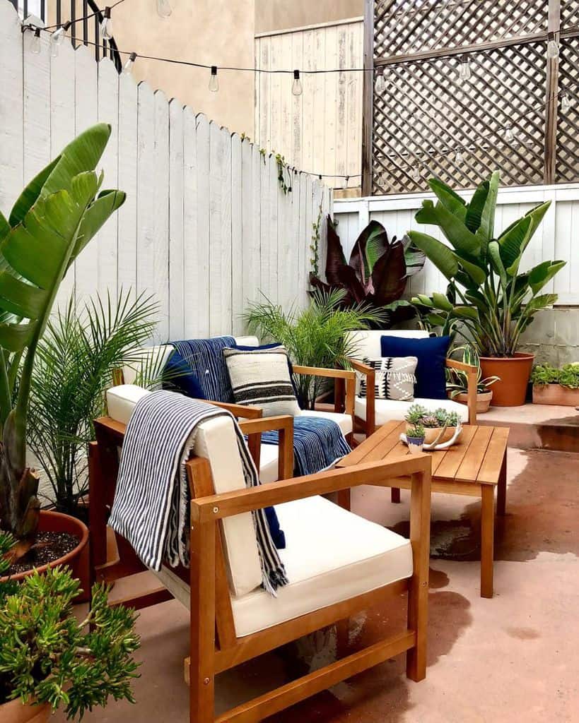 small narrow patio with wood chairs and table