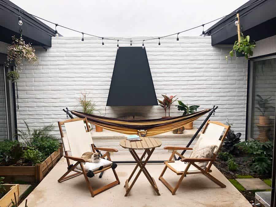 modern patio with table chairs and hammock