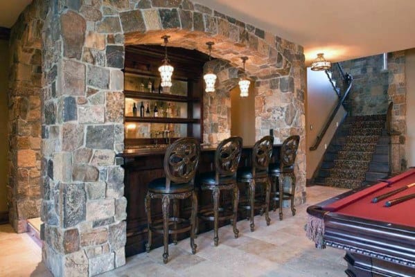 Basement with natural stone bar, elegant barstools, and snooker table nearby.