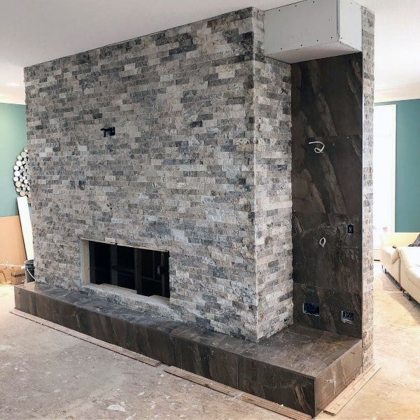 Modern fireplace with stacked natural stone design and sleek dark base, offering a contemporary focal point.