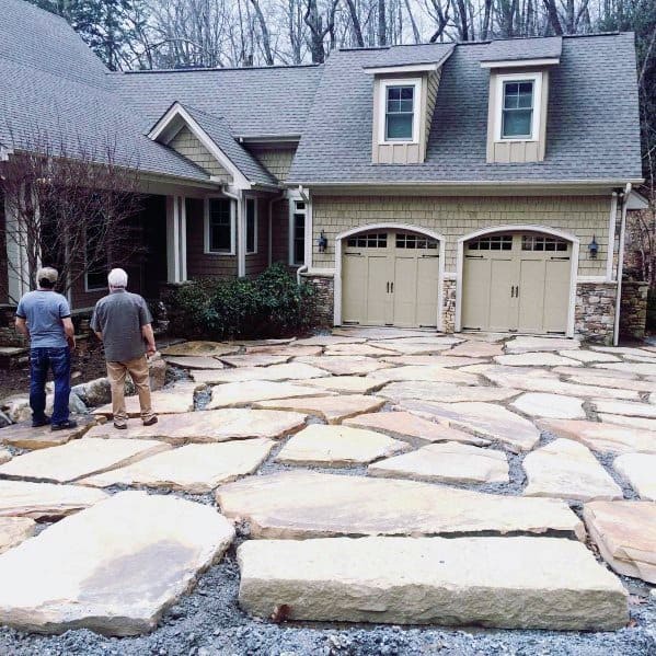 Large, uneven natural stone slabs form a rustic and durable driveway surface.