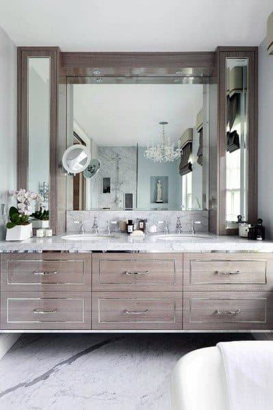 Natural wood double vanity with marble countertop and large framed mirrors.