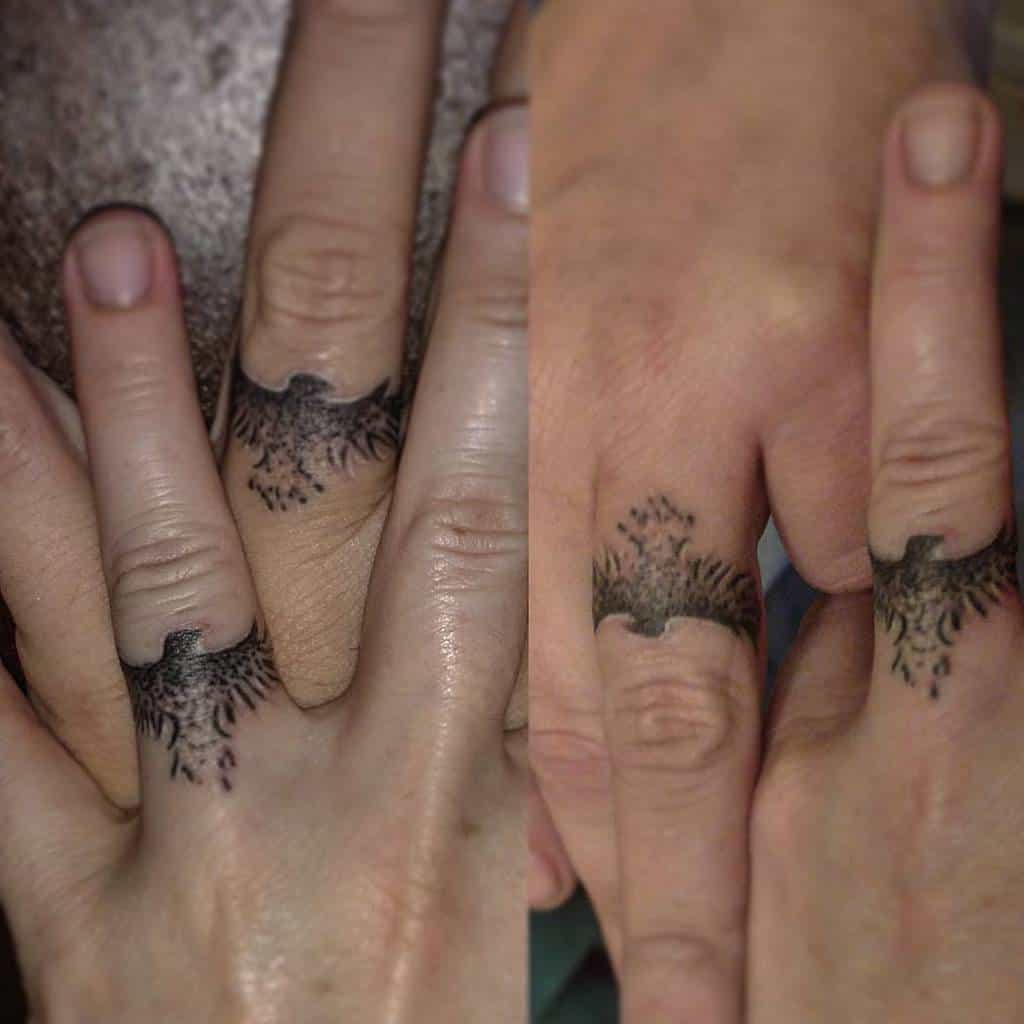Matching wedding ring tattoos of intricate feather or wing designs, symbolizing freedom, connection, or unity