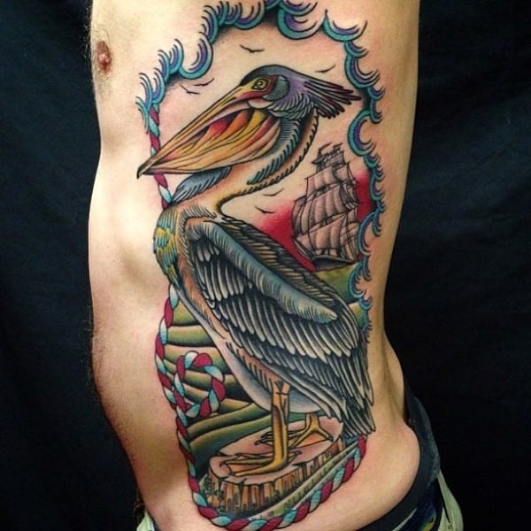 Detailed tattoo of a pelican and ship on a person's side torso