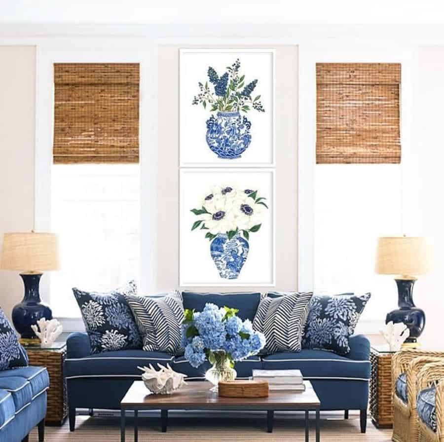 Bright living room with navy blue sofas, floral wall art, and hydrangea centerpiece.