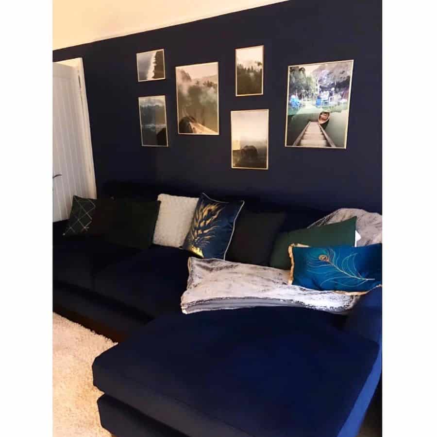 Navy blue living room with a sectional sofa, decorative pillows, and photo wall gallery.