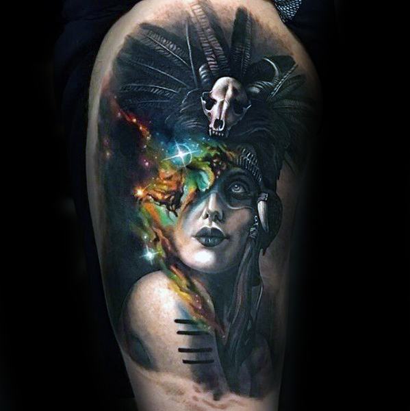 Nebula tattoo of a woman's face with feathers and a skull headdress against a vibrant, dark background