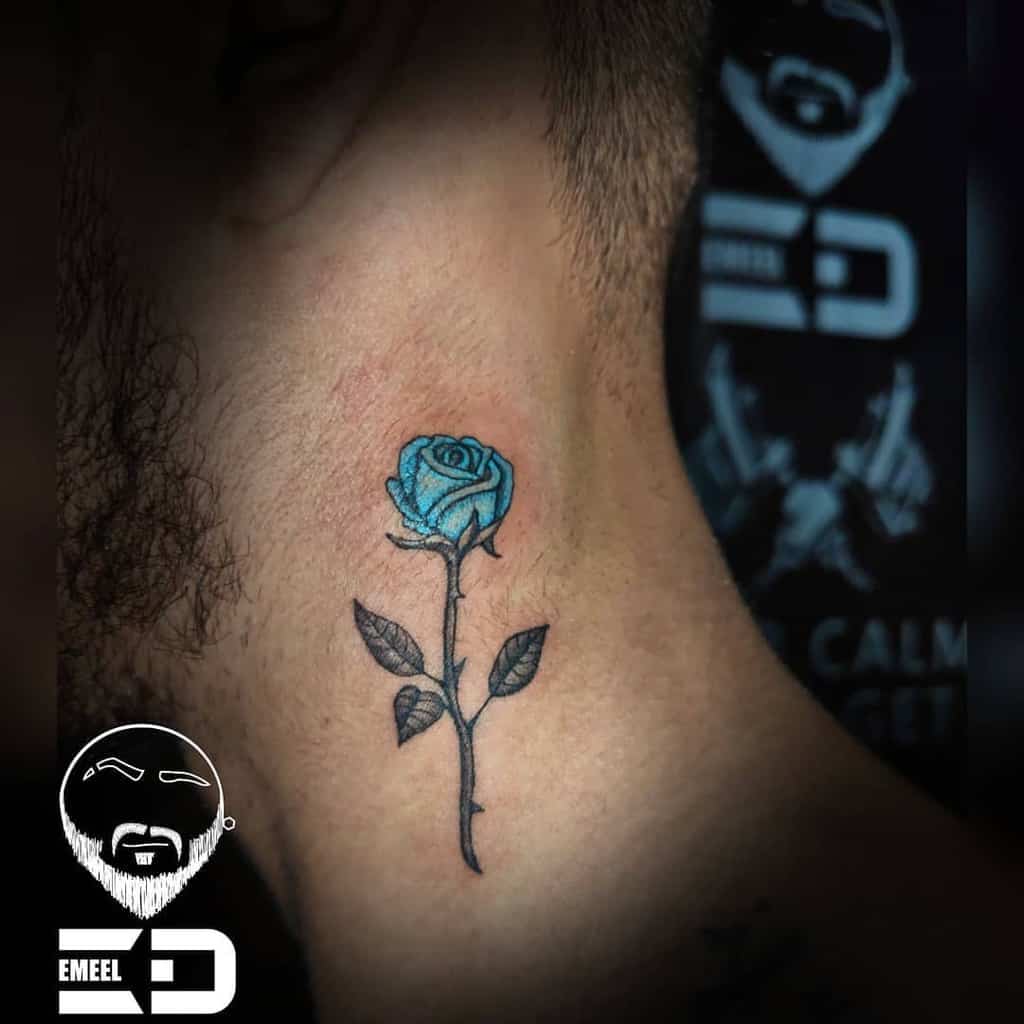 A delicate blue rose tattoo gracefully adorns the side of a person's neck, its intricate petals capturing attention with an air of mysterious elegance