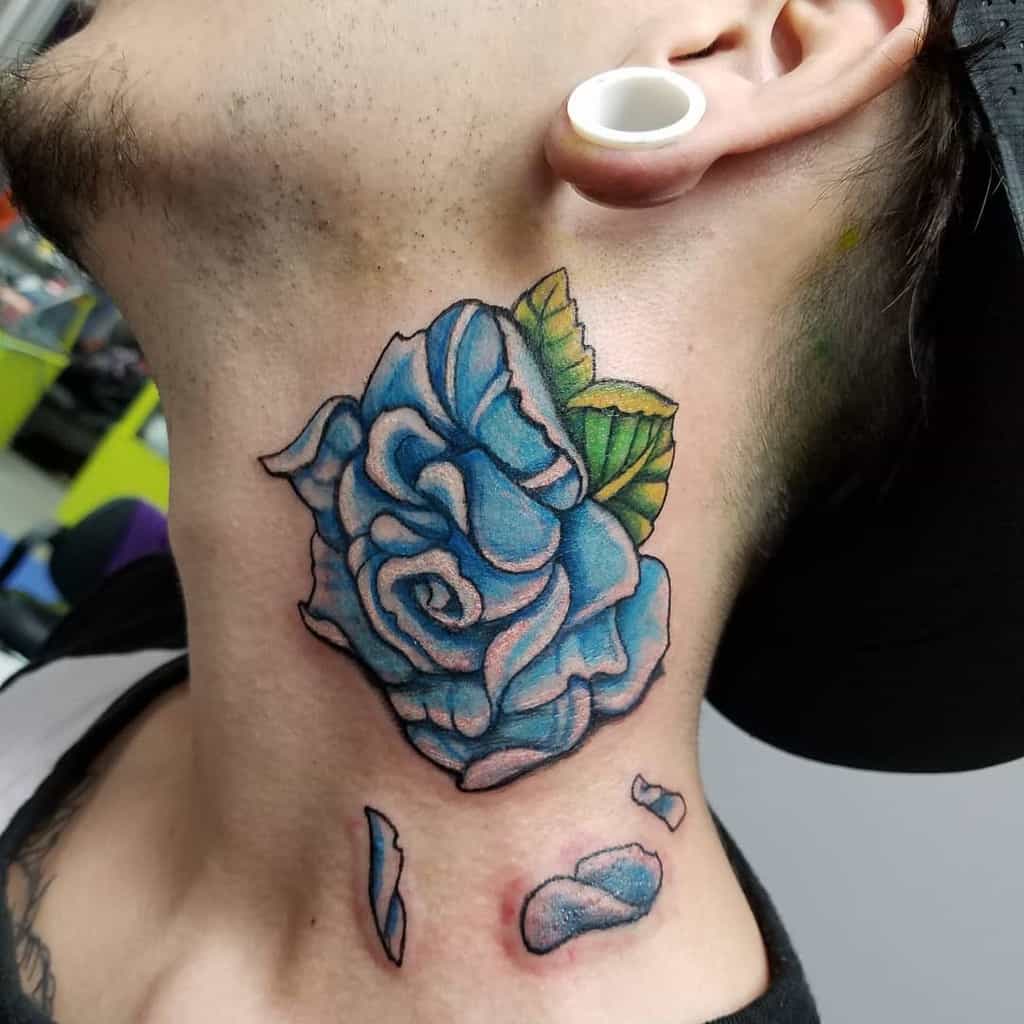A blue rose neck tattoo, vibrant and captivating, features lush green leaves and scattered petals cascading gracefully