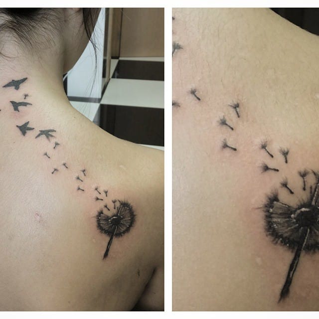A delicate black ink tattoo of a dandelion with seeds blowing in the wind, transitioning into birds. The design symbolizes freedom and transformation.