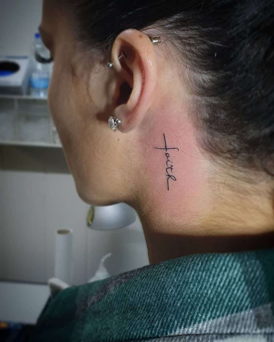 Woman with a "faith" tattoo behind her ear