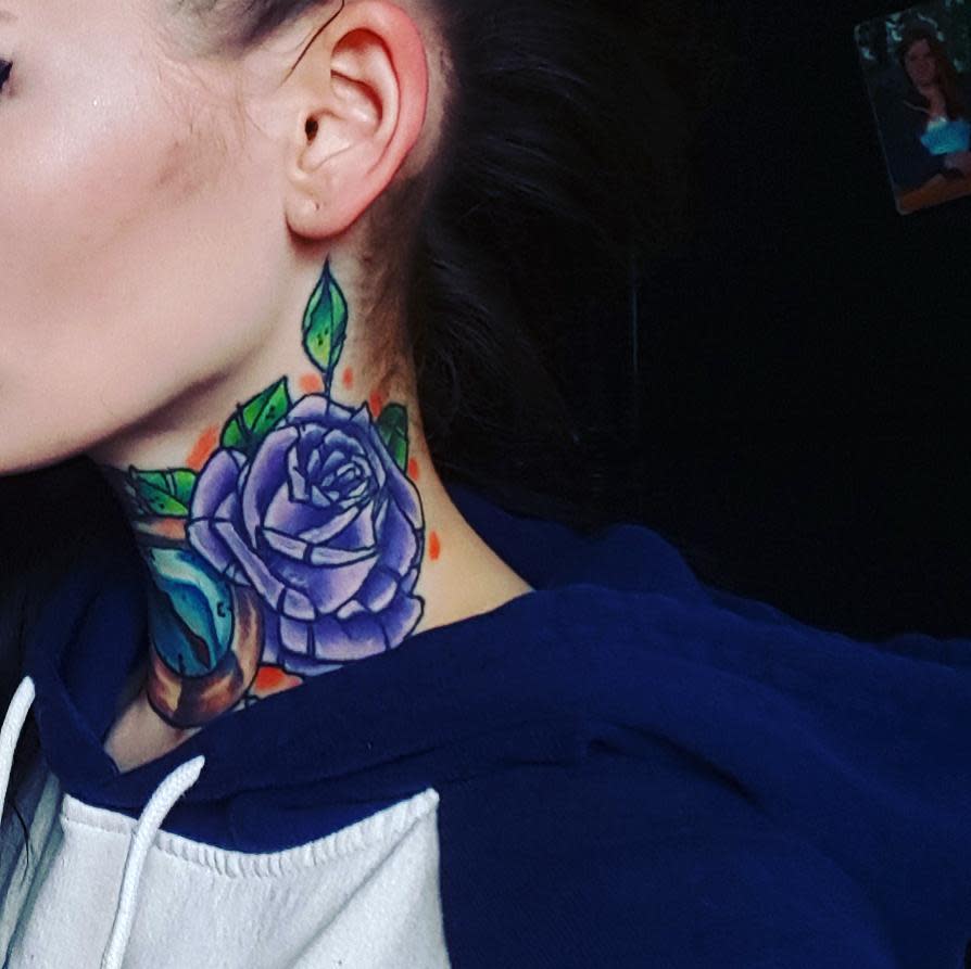 A woman with a colorful purple tattoo on her neck