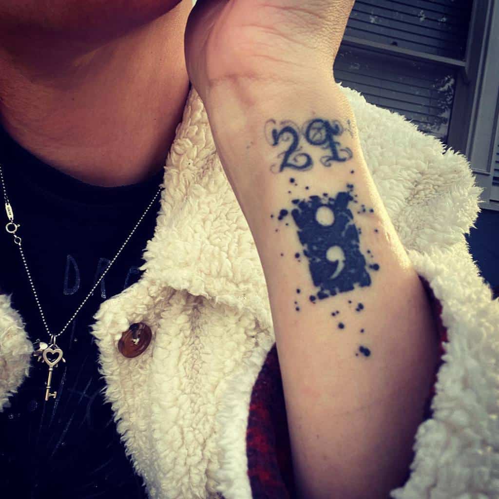 Close-up of a forearm tattoo with a semicolon