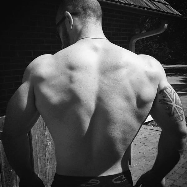 Negative Space Guys Tricep Tattoo Of Chi Rho