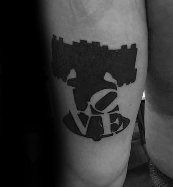 Negative Space Love Liberty Bell Mens Thigh Tattoo With Black Ink Design
