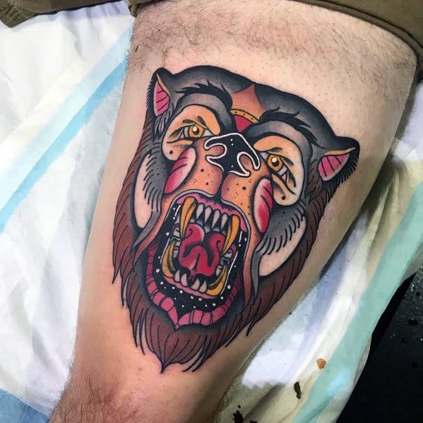 Neo-traditional bear tattoo on the thigh featuring a fierce roaring bear with bold black outlines, vibrant red and yellow accents, and stylized details.