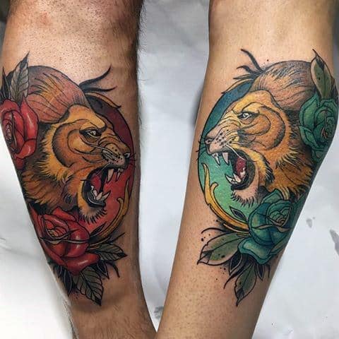 Matching neo-traditional lion tattoos on forearms with roaring expressions, framed by red and teal roses in bold circular backgrounds.