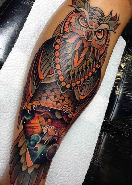 Neo-traditional owl tattoo with intricate patterns, bold orange accents, and a cosmic scene in its talons, blending mysticism and geometry.
