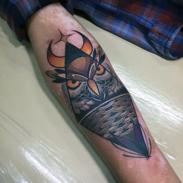 Neo-traditional owl tattoo with geometric elements, bold shading, and a crescent moon, creating a modern and mystical forearm design.