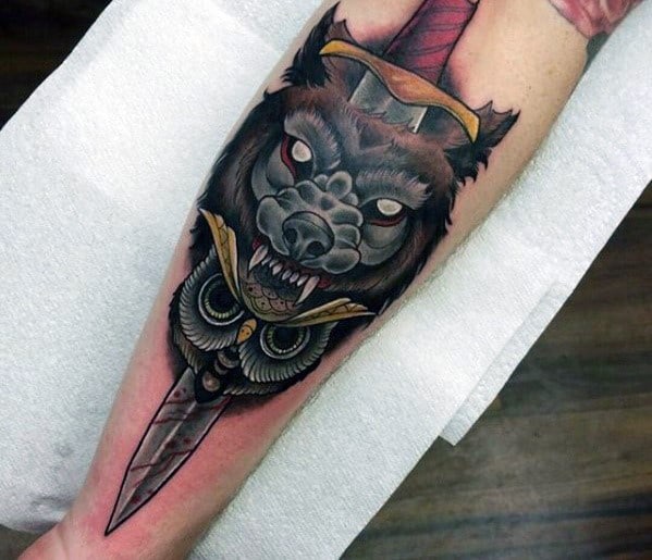 Neo-traditional tattoo featuring a fierce wolf with glowing eyes, an owl, and a dagger, blending bold shading and dramatic symbolism.