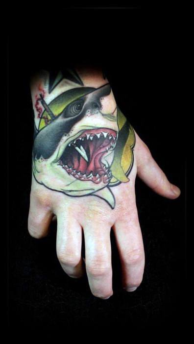 Neo-traditional hand tattoo of an aggressive shark with wide open jaws, a smoking cigar, and bold yellow shading behind the head.