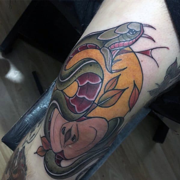 Neo-traditional tattoo of a coiled snake with bold green and red scales, wrapped around an orange circular backdrop and delicate floral elements.