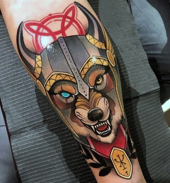 Neo-traditional tattoo of a fierce wolf wearing a Viking-style helmet, one blue eye, bold shading, and a Nordic symbol for a warrior aesthetic.