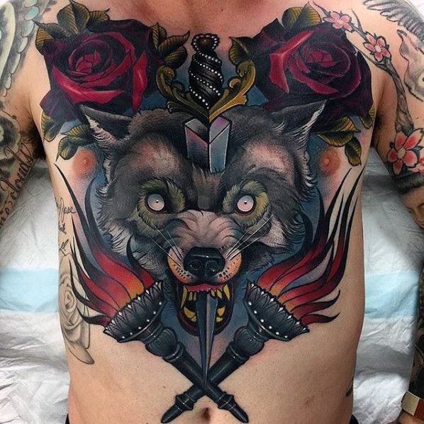 Tattoo of a wolf with roses, a dagger, and crossed torches on a person's chest