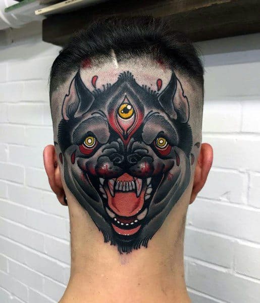 Bold neo-traditional tattoo of a three-eyed snarling wolf covering the back of the head, with vivid red, black, and gold accents.