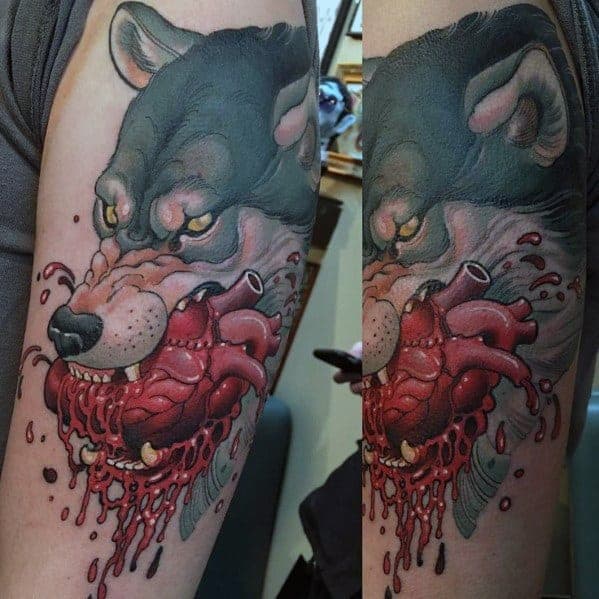 Tattoo of a fierce wolf holding a bloody human heart in its mouth on a person's arm