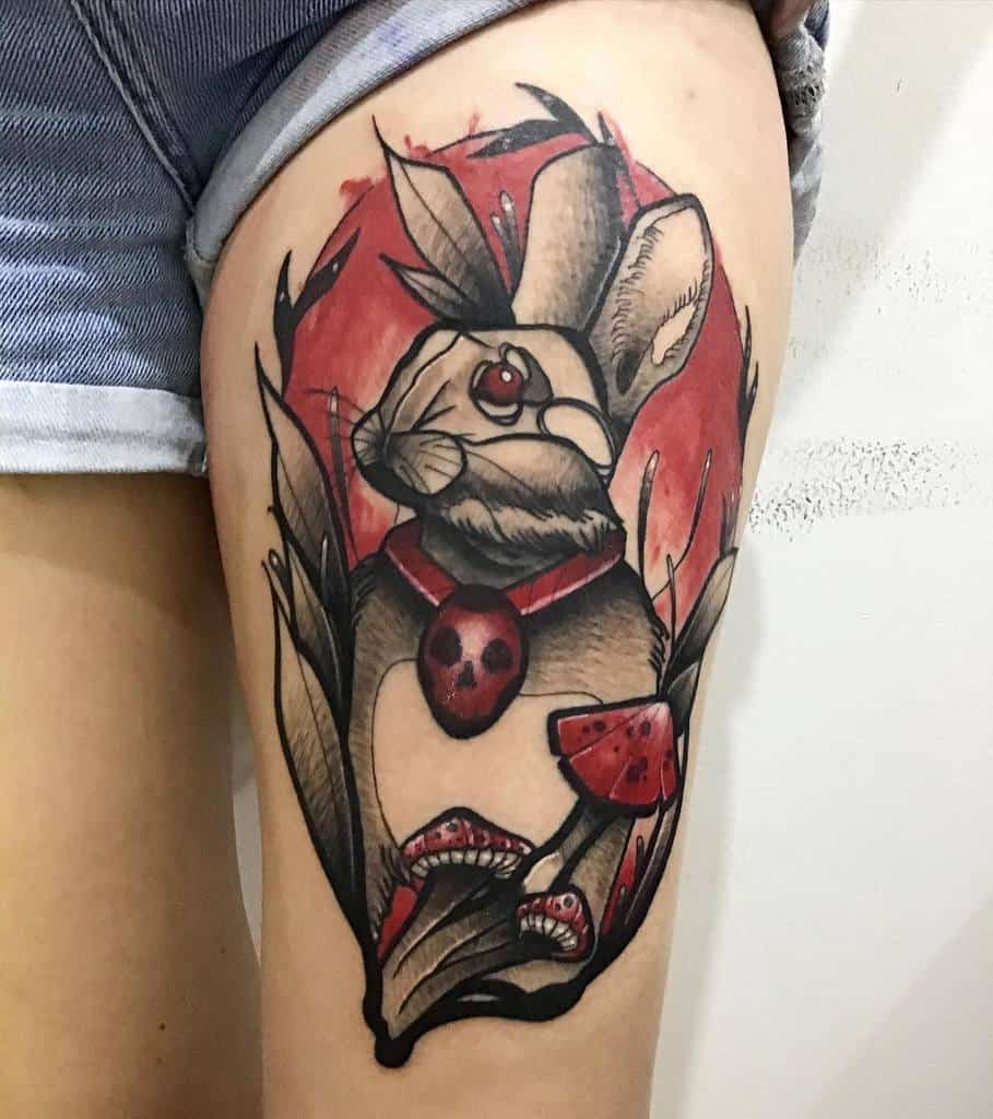 Tattoo of a rabbit with a red eye and necklace, surrounded by mushrooms and leaves in a circle red background