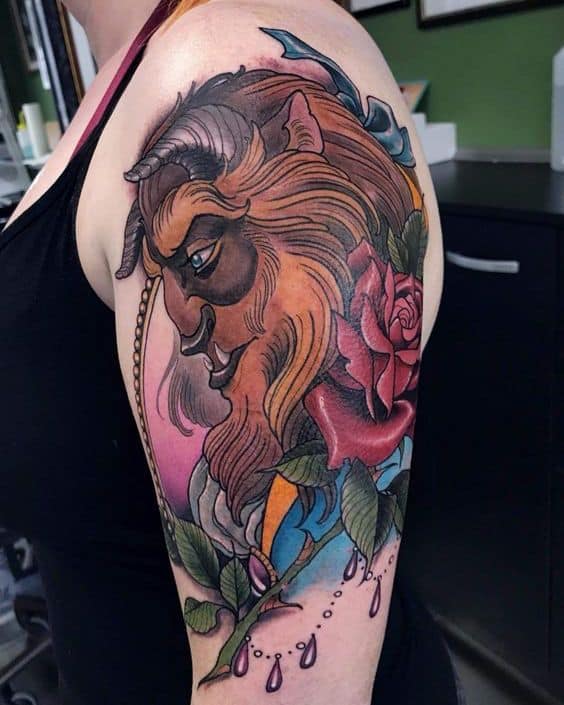 Detailed upper arm tattoo of the Beast with flowing fur, a vibrant red rose, and decorative elements in a bold, colorful style.