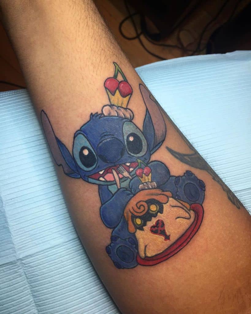 Colorful tattoo of Stitch from Kingdom Hearts enjoying ice cream, sitting with a Heartless emblem dessert, featuring bold shading and vibrant colors.