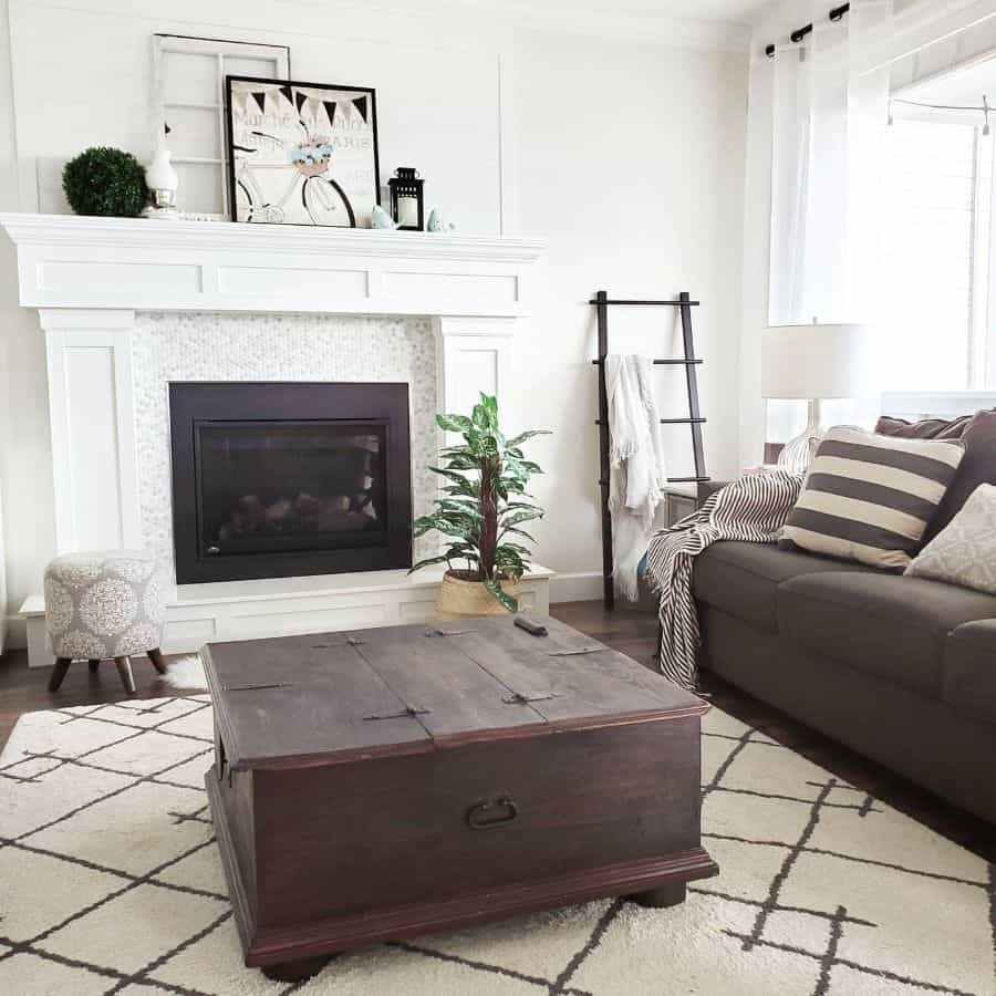 simple white living room brown chest table fireplace gray sofa ladder decoration