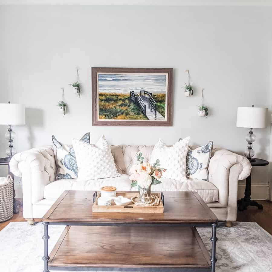 country style living room white sofa brown table wall painting hanging pot plants