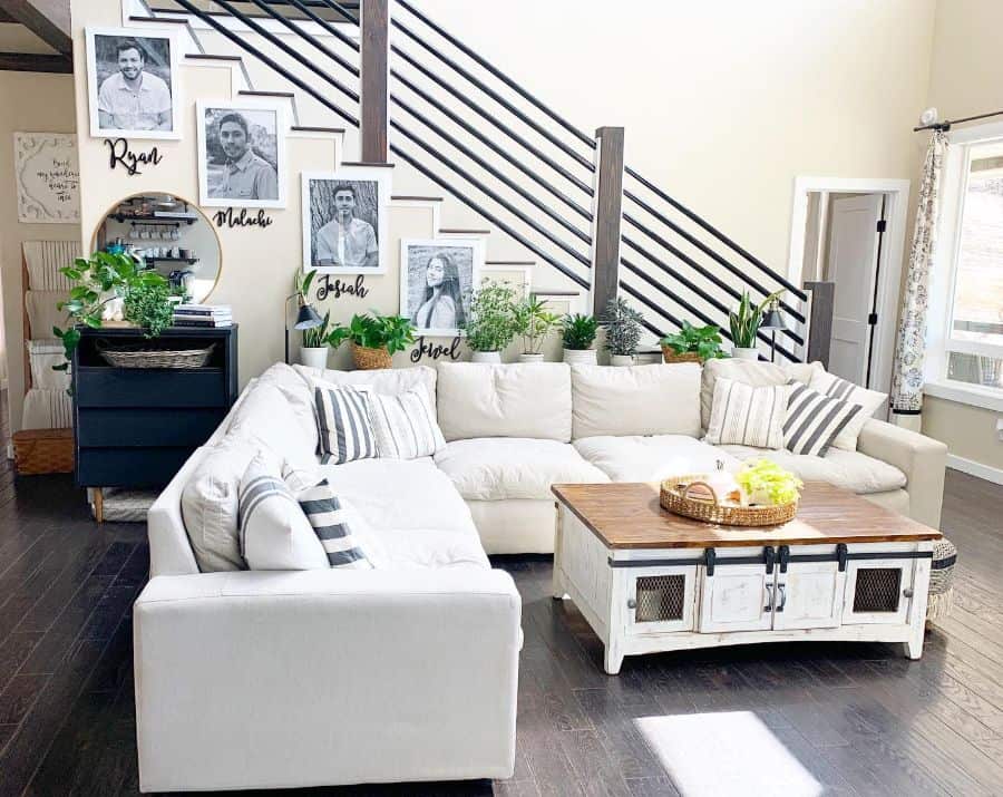 farmhouse living room l-shape white sofa large cabinet table hardwood floors photo wall art