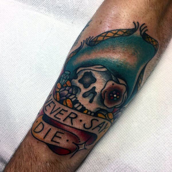 Colorful traditional-style tattoo of a pirate skull wearing a blue hat, with a banner reading "Never Say Die," inspired by The Goonies.