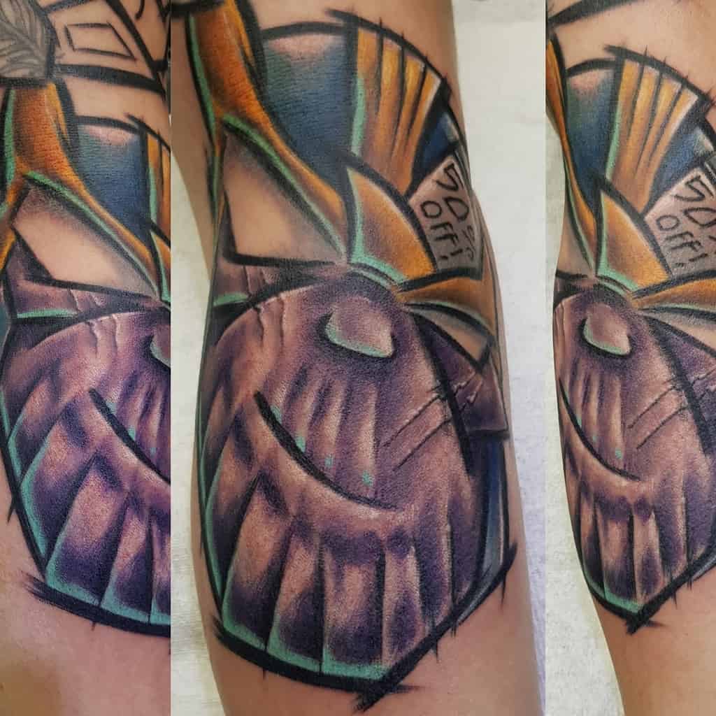 A bold Thanos tattoo featuring the Infinity Gauntlet, vivid colors, and dynamic shading