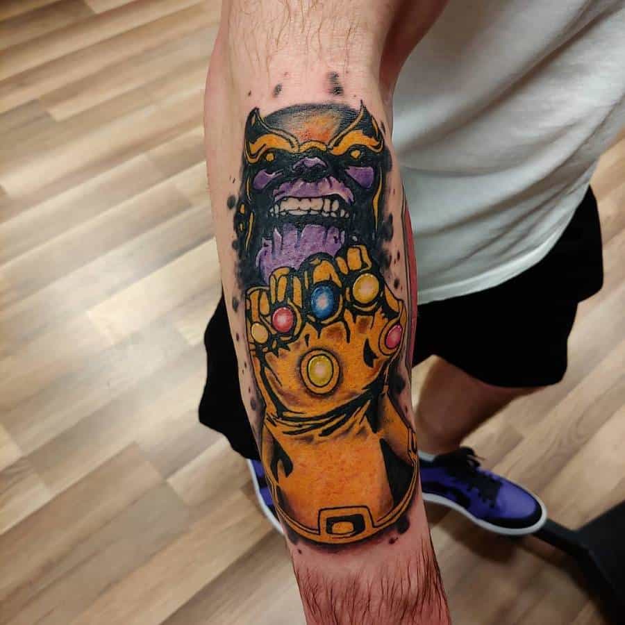 Bold Thanos tattoo featuring an intense expression and the Infinity Gauntlet, glowing with all six Infinity Stones