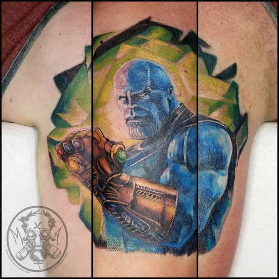 Epic Thanos tattoo featuring a blue-toned design, the Infinity Gauntlet, and a dynamic background