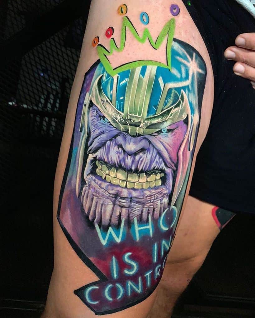 Thanos tattoo featuring his menacing grin, bold colors, a neon-style "Who is in control" text, and a crown with Infinity Stones