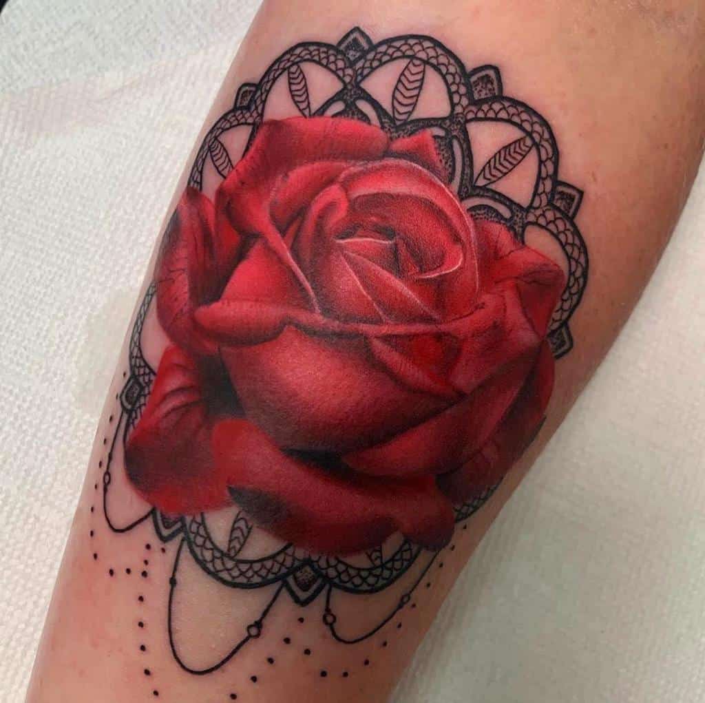 Realistic red rose tattoo with intricate black mandala and dot work, creating a bold contrast and elegant floral design
