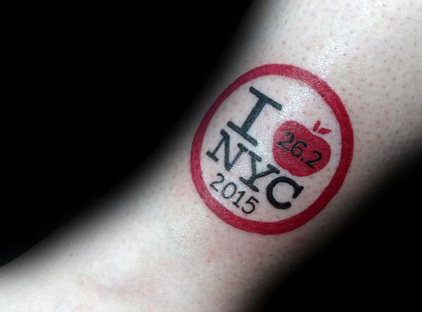 “I ❤️ NYC” style tattoo with a red apple marked 26.2 and the year 2015, honoring the New York City Marathon.